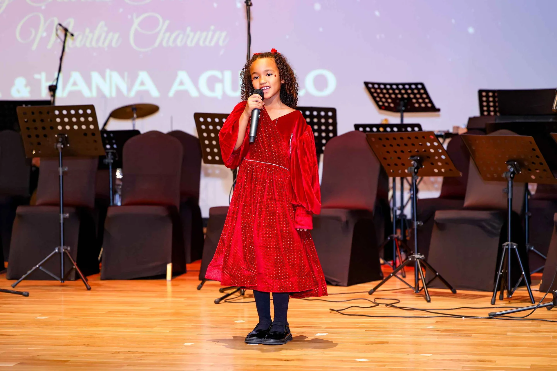 Student performing on stage during a music activity at Nibras International School
